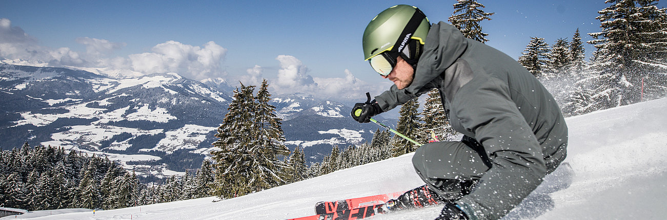 Skifahrer auf der Piste mit Panoramablick auf die Umgebung